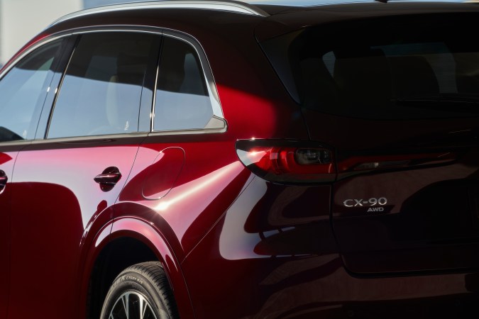 Detalle trasero Mazda CX-90 AWD en rojo, vista lateral posterior con diseño premium