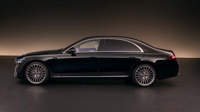 Mercedes-Benz Clase S 2027 en vista lateral, sedán negro de lujo con diseño elegante y rines multirradio en estudio.