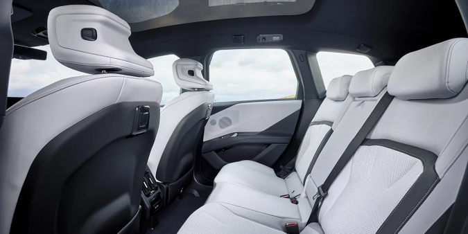 Asientos traseros BMW iX3 con amplio espacio y tapicería en cuero blanco, interior espacioso del SUV eléctrico.