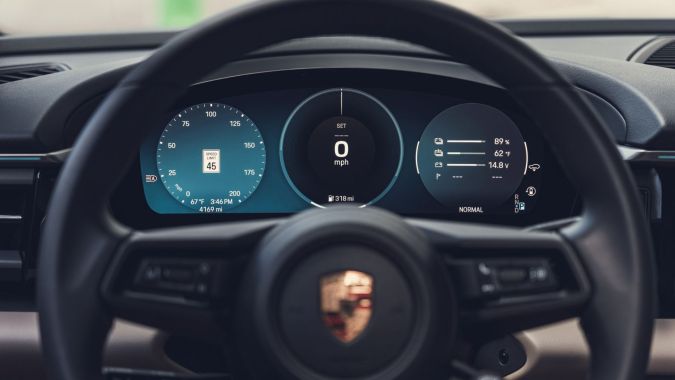 Interior Porsche Macan Eléctrico, detalle del volante y cuadro de instrumentos digital con información de conducción.