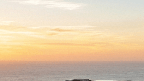 Ford Explorer vs Mazda CX-90 roja comparativa en carretera costera al atardecer