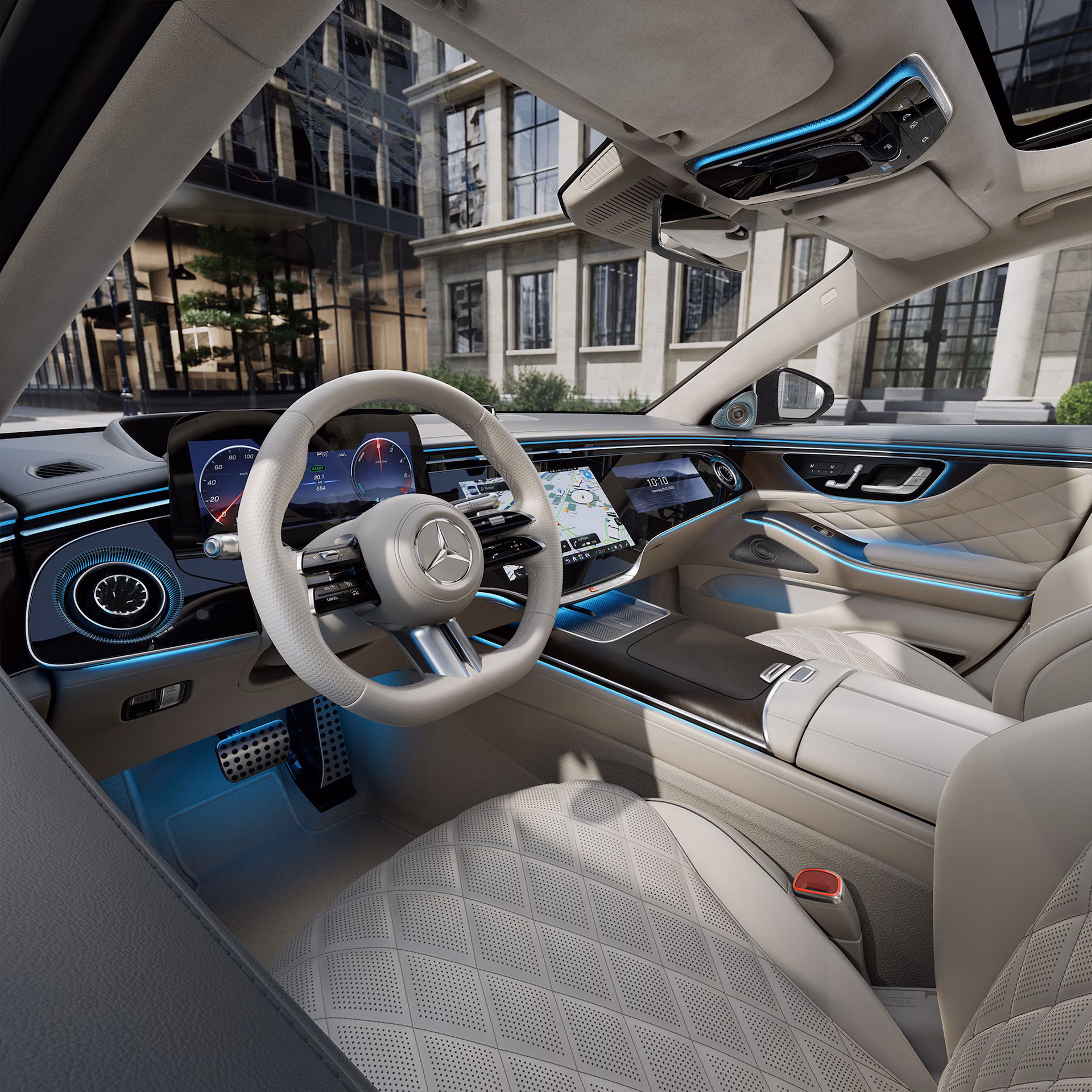 Interior del Mercedes-Benz Clase S con cockpit digital, volante multifunción y luces ambientales azules en un habitáculo de lujo.