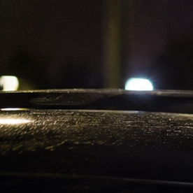Agente de policía haciendo prueba de alcoholemia a conductor dentro de su vehículo por la noche. Control de ebriedad.