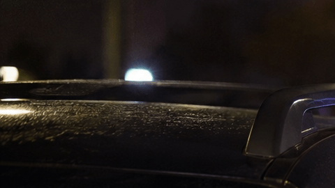 Agente de policía haciendo prueba de alcoholemia a conductor dentro de su vehículo por la noche. Control de ebriedad.