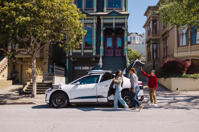 Grupo de personas subiendo a un robotaxi de Waymo en una calle de San Francisco