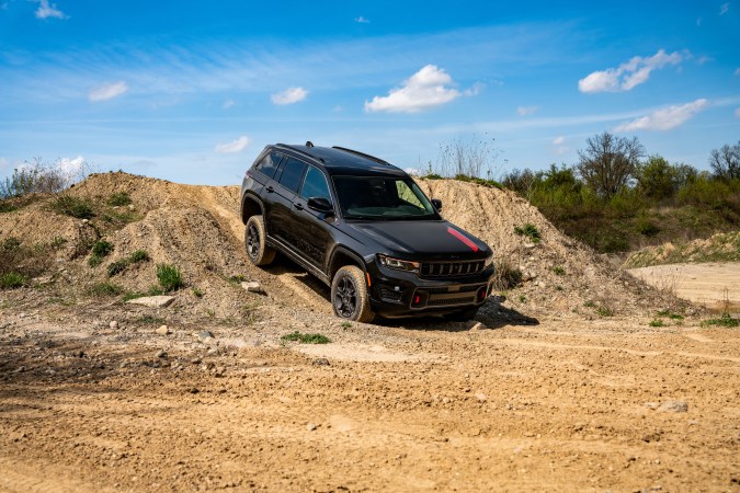 Jeep Grand Cherokee Trailhawk 2027 negro descendiendo colina de tierra, demostrando capacidad 4x4, suspensión elevada y control en terrenos off-road exigentes.
