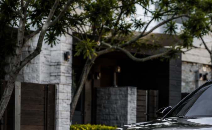 Nuevo Chrysler SUV eléctrico gris con líneas premium, estacionado en entorno residencial de lujo.