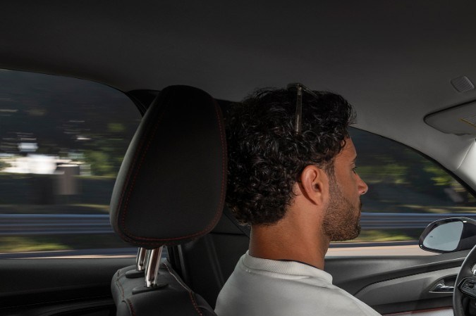 Interior del Chevrolet Bolt 2027 con conductor al volante, mostrando el moderno salpicadero y pantalla táctil del SUV eléctrico.