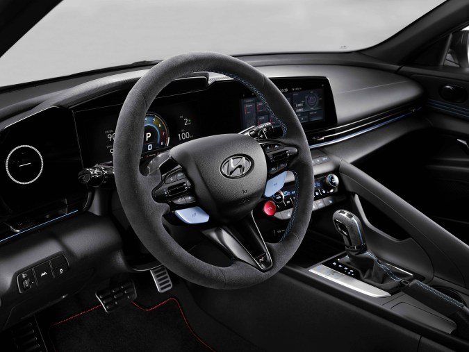Interior Hyundai Elantra N 2026 con volante deportivo N, tablero digital y asientos con costuras azules.