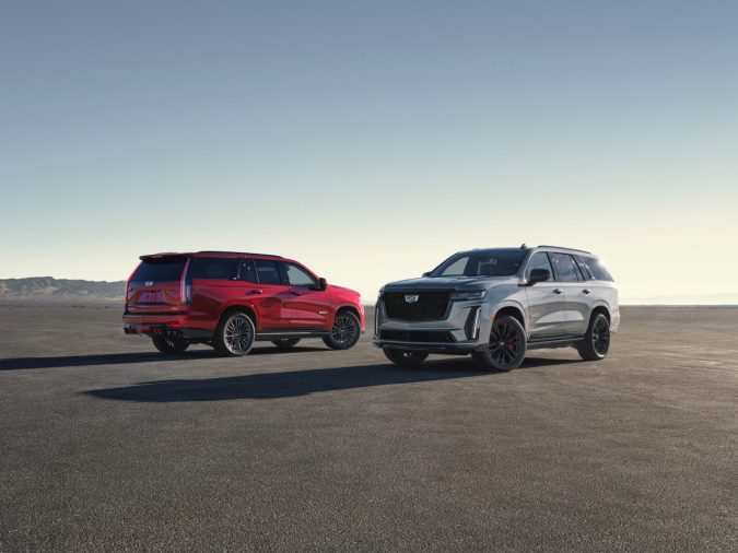 Cadillac Escalade V rojo y gris en desierto, dos potentes SUV de lujo americanos en paisaje árido