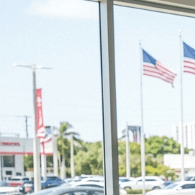 Mujer latina firma papeles para comprar un auto nuevo en un concesionario de Estados Unidos.