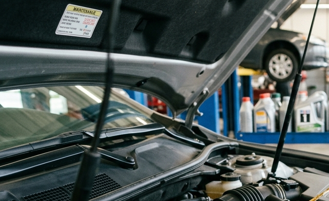 Mecánico profesional revisando motor Toyota en taller, midiendo aceite y realizando mantenimiento para mejorar rendimiento y alargar la vida del vehículo.
