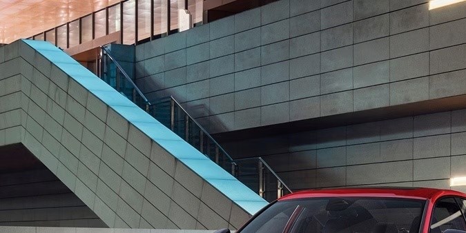 Honda Accord 2026 rojo y gris exhibidos frente a edificio moderno. Sedanes confiables y de alto diseño.