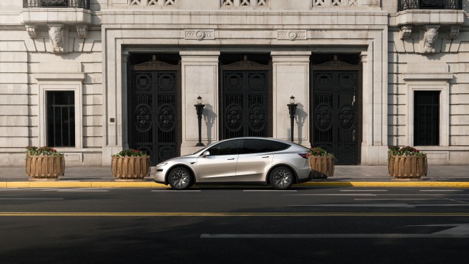 Tesla Model Y plateado frente a edificio neoclásico en la calle