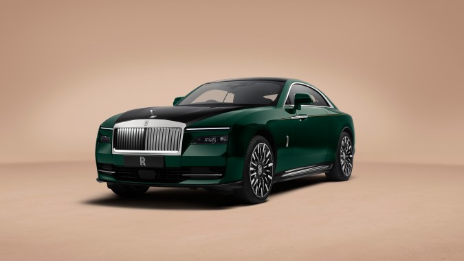 Vista frontal tres cuartos Rolls-Royce Spectre Series II verde, parrilla icónica, capó negro y diseño imponente del nuevo coupé eléctrico de lujo.