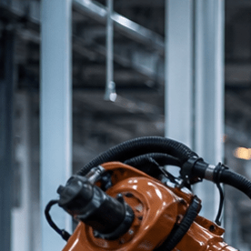 Robots industriales ensamblando chasis de auto en moderna planta automotriz integrada de Norteamérica con banderas T-MEC USMCA.