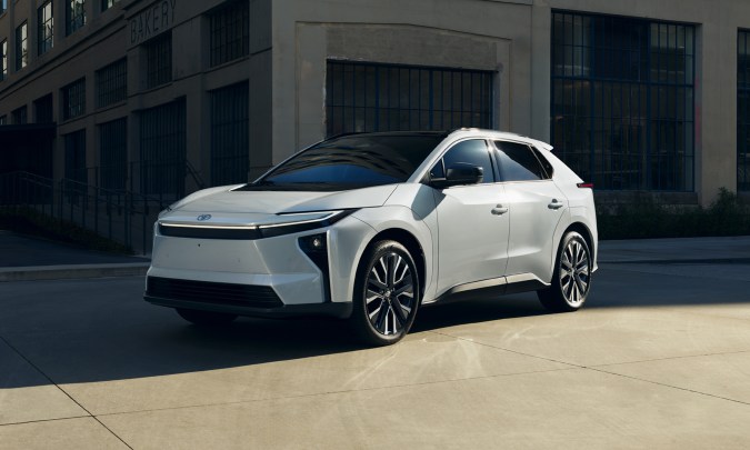 Toyota bZ 2026 blanco circulando en ciudad moderna, SUV eléctrico premium en entorno urbano