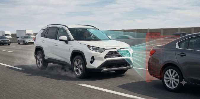 Toyota RAV4 con Sistema Pre-Colisión PCS detectando vehículo delantero en carretera con alerta de colisión.