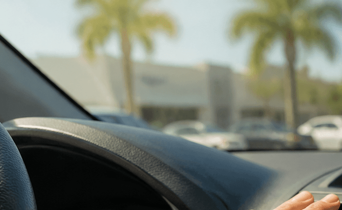 Mano ajustando rejillas de aire acondicionado en el tablero de auto, interior con sistema de climatización en funcionamiento