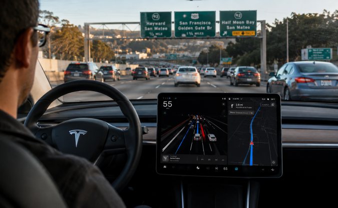Interior de Tesla con Autopilot activado en autopista. Conducción autónoma hacia San Francisco con pantalla y navegación en tiempo real.