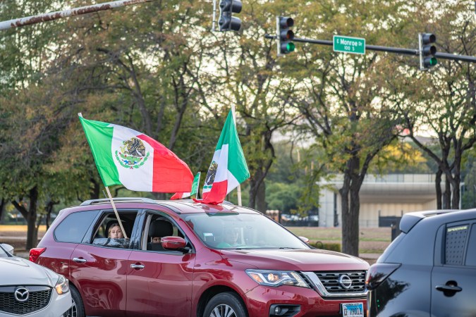 People in cars hang flags out the window and drive through the Loop to celebrate Mexican Independence Day.