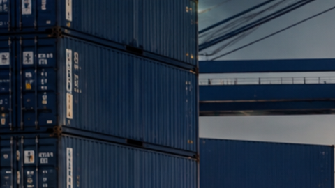 Pickup, SUV y deportivo estadounidense en puerto industrial, listos para exportación junto a contenedores y buque carguero.
