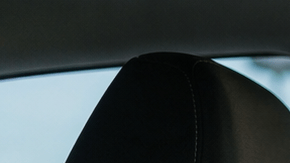 Hombre preocupado colocándose el cinturón de seguridad mientras luz de alerta roja brilla en el tablero del coche.