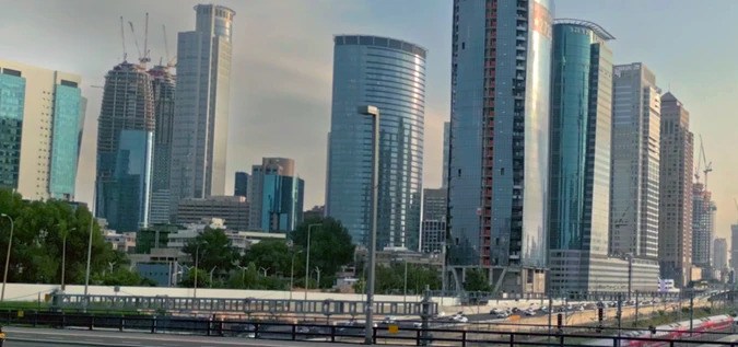 Auto autónomo de Mobileye circula por autopista urbana con rascacielos de fondo