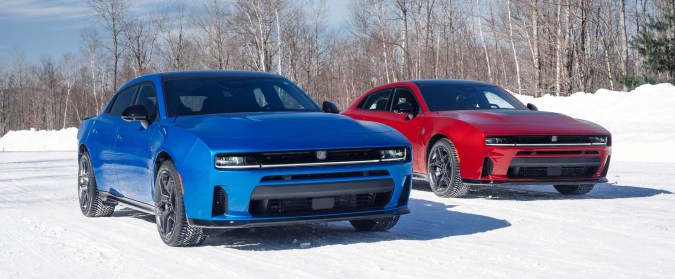 Dodge Charger azul y rojo en paisaje nevado, vista frontal de los potentes sedanes deportivos en invierno