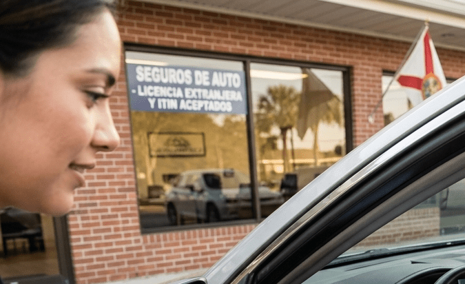 Agente de seguros entregando cotización de seguro de auto a nuevo residente hispano con pasaporte y licencia extranjera en Estados Unidos.