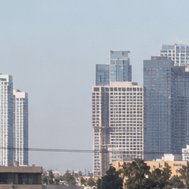 Tráfico pesado en autopista de Los Ángeles California con skyline de downtown al fondo, congestión vehicular en hora punta.