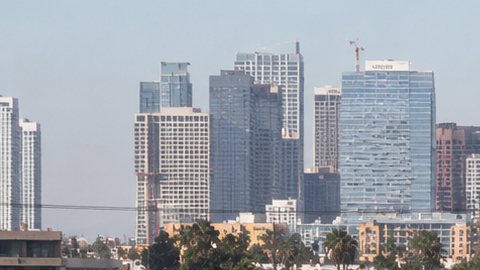 Tráfico pesado en autopista de Los Ángeles California con skyline de downtown al fondo, congestión vehicular en hora punta.