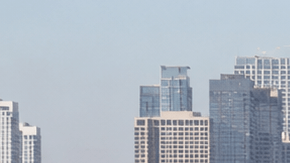 Tráfico pesado en autopista de Los Ángeles California con skyline de downtown al fondo, congestión vehicular en hora punta.