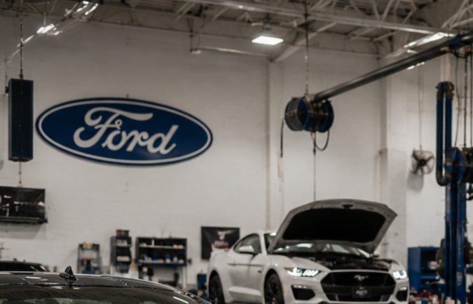 Taller de servicio Ford con varios Mustang en revisión mecánica por recall.