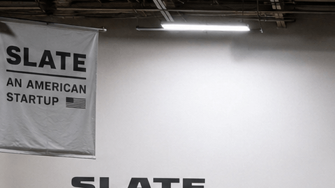 Tres versiones de la Slate Truck eléctrica con accesorios y opciones de personalización en un estudio.