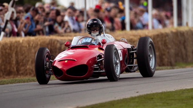 Ferrari rojo clásico de los años 50 en acción en Goodwood Revival, leyenda del automovilismo vintage con piloto