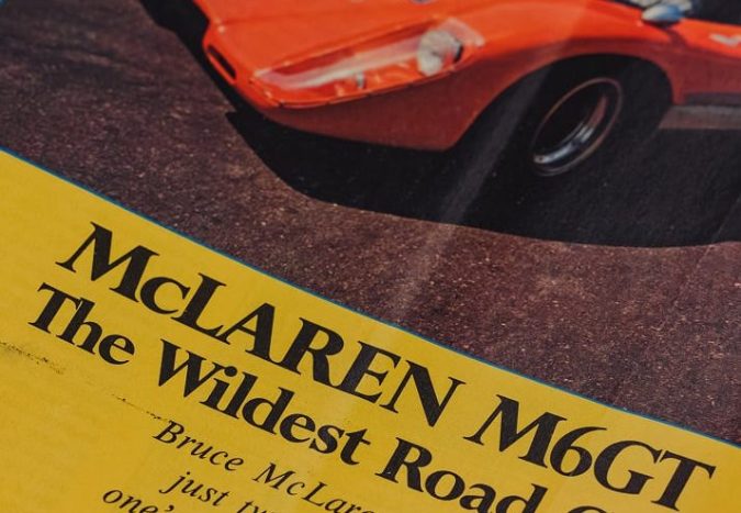 Revista vintage con portada dedicada al McLaren M6GT, el ‘wildest road car’, texto y foto del deportivo naranja.