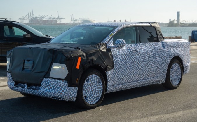 Ford Ranchero EV prototipo camuflado visto de lado en pruebas reales, pickup eléctrica de Ford en desarrollo.