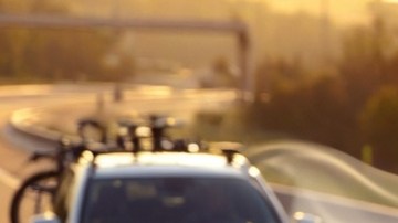 Auto con baúl portaequipaje aerodinámico en el techo, optimizando flujo de aire, estabilidad y consumo de gasolina en carretera.