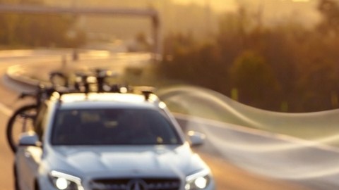 Auto con baúl portaequipaje aerodinámico en el techo, optimizando flujo de aire, estabilidad y consumo de gasolina en carretera.