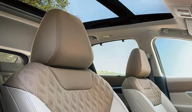 Interior del Nissan Murano 2027 con asientos de cuero color beige, techo panorámico y pantalla táctil central.
