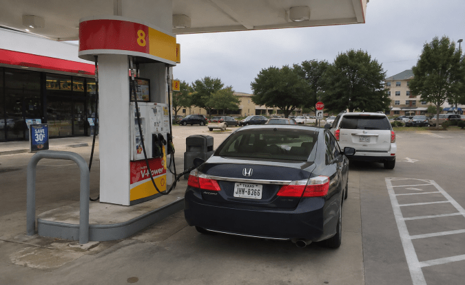 Auto Honda estacionado frente a surtidor de gasolina Shell en una estación de servicio de Texas.