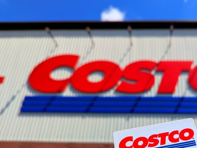 Tarjeta de membresía Costco Gold Star frente a una tienda Costco en Estados Unidos.