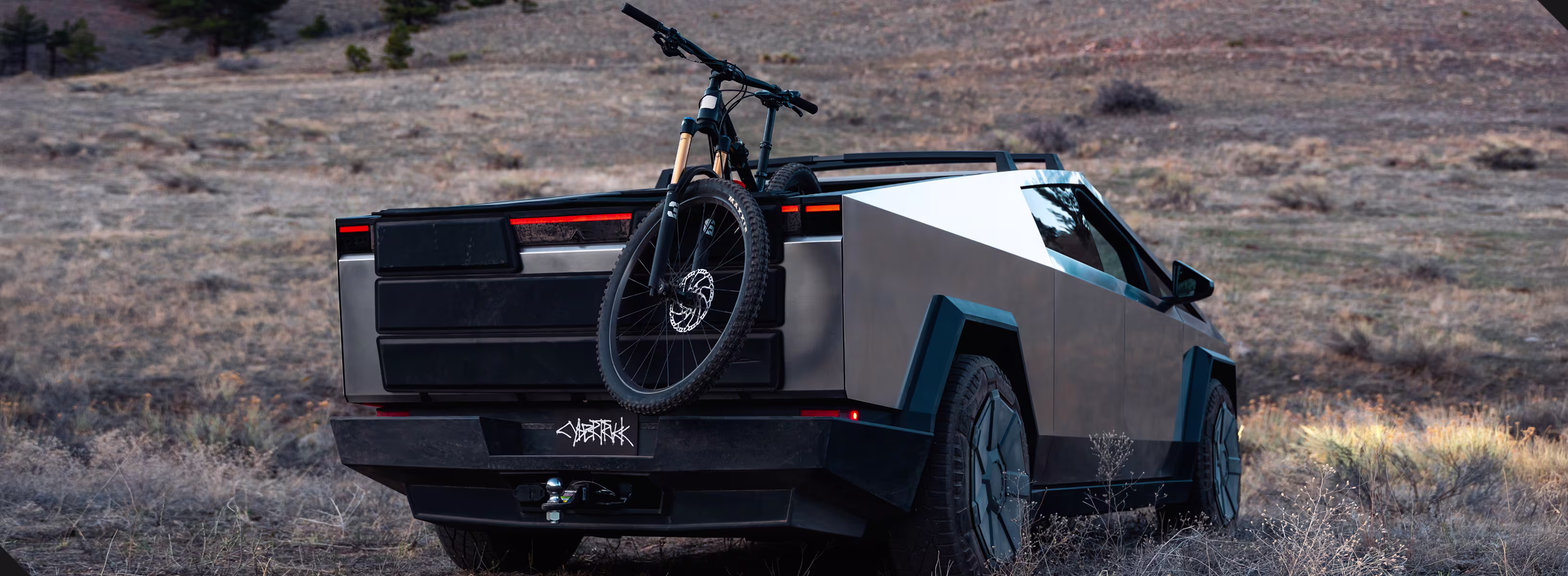 Tesla Cybertruck todoterreno con bicicleta de montaña instalada en la caja trasera.