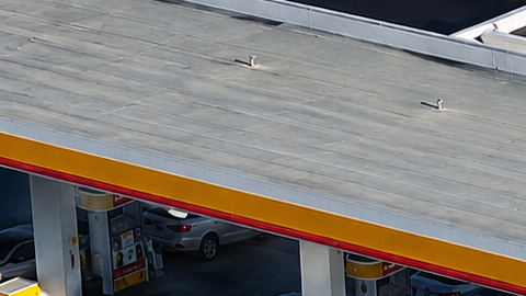 Vista aérea de gasolinera Shell y Circle K con varios autos estacionados junto a las bombas.