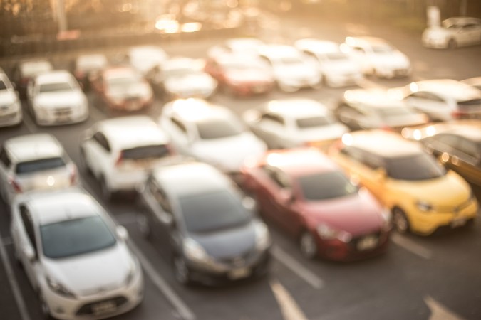 Fondo abstracto borroso de estacionamiento de autos con luz solar, Auto para rentar