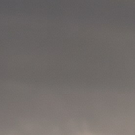 Cinco vehículos todoterreno de distintas marcas, incluyendo Tesla Cybertruck y Jeep Wrangler, avanzan en formación por un desierto árido al atardecer.