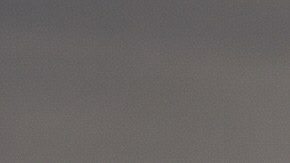 Cinco vehículos todoterreno de distintas marcas, incluyendo Tesla Cybertruck y Jeep Wrangler, avanzan en formación por un desierto árido al atardecer.