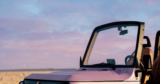 CHIP eléctrico púrpura en playa al atardecer con puertas abiertas y asientos marrones