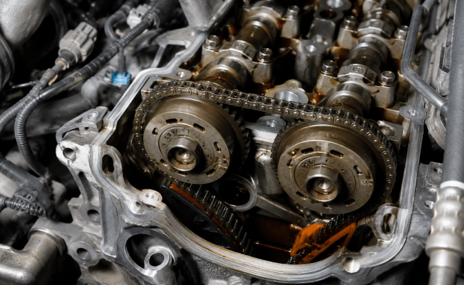 Motor con árbol de levas y cadena de distribución expuestos para diagnosticar vibraciones y fallas mecánicas en el carro.